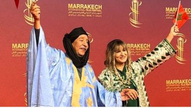 صورة عبد الإله عاجل زوجته يسرقان الأضواء برفع العلم المغربي على السجادة الحمراء